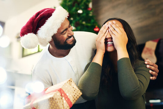 Christmas Surprise, Gift And Couple In Home With Husband And Wife Having Fun And Bonding On Holiday. Xmas, Love And Woman With Eyes Closed Receiving Box Of Presents From Man For Festive Celebration.