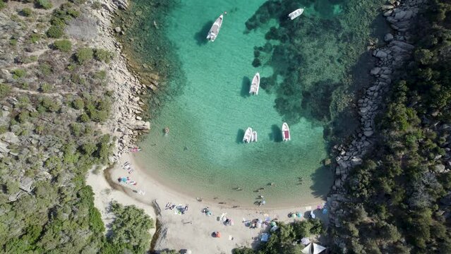 Tizzano Beach Las Cricas cove in Corsica Island Mediterranean Sea French territory with boats and bathing tourists, Aerial top view rising shot