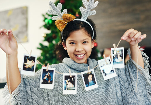 Christmas, Celebration And Girl With Polaroid For Decoration, Happy And Show Photos In The House. Smile, Excited And Portrait Of A Child With Pictures To Decorate The Home For A Festive Xmas