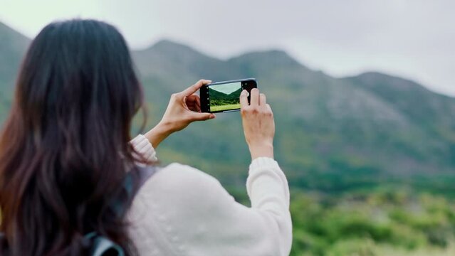 Photography, nature and mountain with a woman using her phone while sightseeing during travel or vacation. Freedom, mountains and smartphone with a female traveler taking a picture of the wilderness