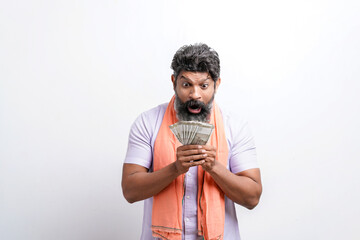 Indian farmer giving shocking expression with money on white background.