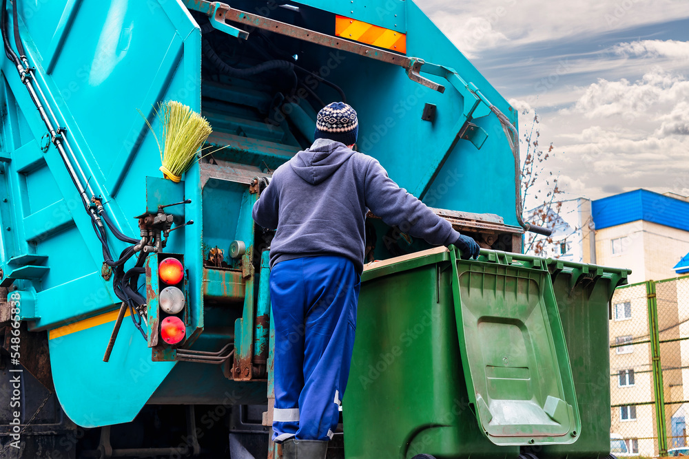 Poster A garbage truck picks up garbage in a residential area. Loading mussar in containers into the car. Separate collection and disposal of garbage. Garbage collection vehicle.