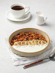 Portion of gourmet granola breakfast with banana and yoghurt