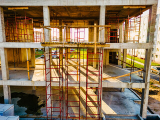 Construction of a monolithic reinforced concrete house. Close-up of a building under construction. The sun's rays illuminate the construction site. Shooting from a drone. Modern building in the city.