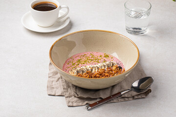 Portion of gourmet granola breakfast with banana and berry yoghurt