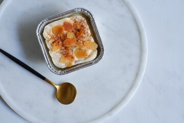  a cup of baked coconut custard cake or klappertaart in white background 