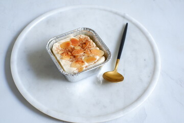  a cup of baked coconut custard cake or klappertaart in white background 