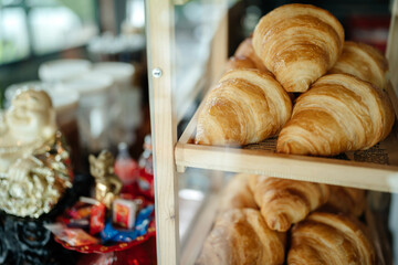 Fresh croissants lie in the window of a French cuisine store.