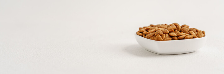 Cat food in a white bowl top view near the copy space, wide format for the banner