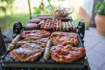 Delicious beef and pork meat, sausages on BBQ grill. Top view.