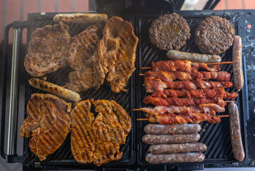 Delicious beef and pork meat, sausages on BBQ grill. Top view.