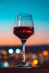 Glass of wine on the city night background