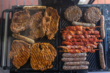 Delicious beef and pork meat, sausages on BBQ grill. Top view.