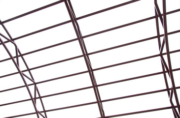 The frame of a metal canopy against the sky.