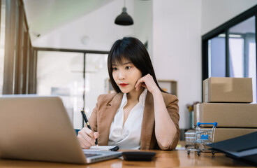 Young asian Woman Thinking and Working on sell online in cozy house, Modern Lifestyle of New Generation People.