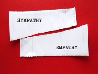 Two torn paper on red background with words EMPATHY (ability to understand feelings as if we were...