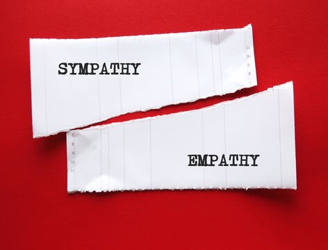 Two torn paper on red background with words EMPATHY (ability to understand feelings as if we were having them ourselves) and SYMPATHY (understanding someone else suffering)