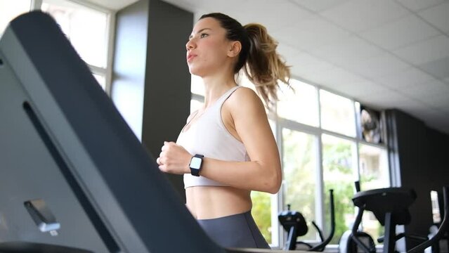 Blonde fit woman jogging in gym.