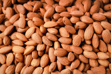 Almonds in white porcelain bowl on white table. Almond concept with copyspace.