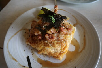 Japanese fried rice omelette topped with pork, seaweed and sesame. (Japanese rice wrapped eggs omelette)