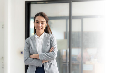 portrait Working woman asian wearing a gray suit, smiling, Crossed hands looking at the camera with confidence at office