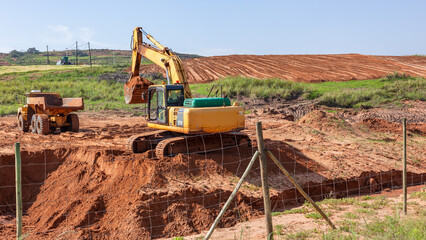 Industrial Earthworks Construction Truck Excavator Heavy Vehicle Machines Moving Sand Earth Along Field Plateau. © ChrisVanLennepPhoto