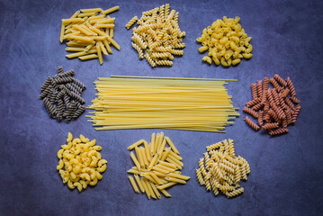 Raw pasta various kinds of uncooked pasta macaroni spaghetti and noodles on wooden, Italian food culinary concept, Collection of different raw pasta on cooking table for cooking food