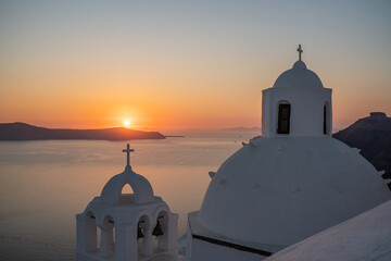 Santorini, white church against colorful sunset in Greece