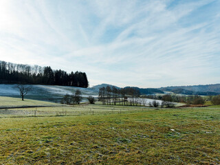 Landscape of meadows and foothills covered in winter frost above Weitenau village in Margraves' land (Markgräflerland)