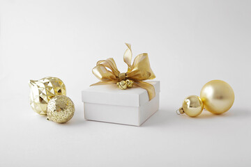 Christmas gift box with golden ribbon bow and ornaments
