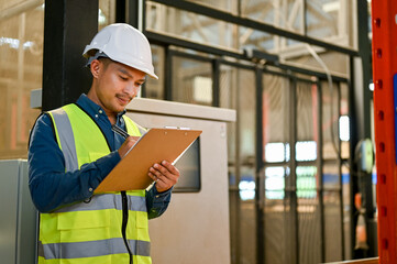 Professional Asian male industrial engineer or warehouse engineer working in warehouse or factory