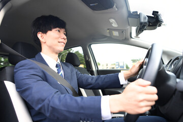 車を運転するスーツ姿のビジネスマン
