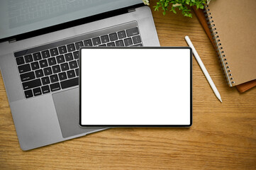 Top view, Minimal workspace with tablet mockup is on laptop on wood background.