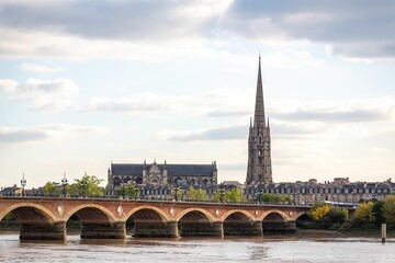 View of St Michel cathedral church in Bordeaux city with a bridge over the river, France