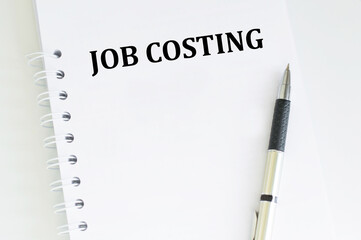 JOB COSTING text on a sticky note on a cork board with pencil
