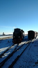 Brocken steam locomotice running up Hill winter blue sky