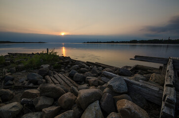 Fototapeta na wymiar Ryazhevoy mooring on the bank of the river. Sunset on the river. Onega. ponga
