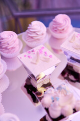 Close-up of bright pink cupcakes on a mirrored stand.