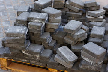 Paving tiles for paving sidewalks. 
Pallets and packages of fresh concrete tiles in the construction warehouse outside. The concept of repair and building materials. top view. 