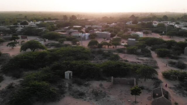 Aerial backward drone shot of small village in the Sindh during senset time. 