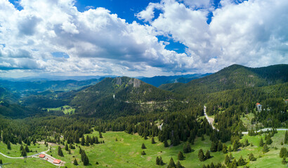 Fototapeta na wymiar Valley of Balkan mountains with fog, sunny clouds and forests. Village Pamporovo. Panorama, top view