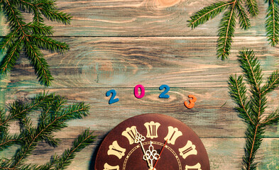 Christmas wooden background with clock and fir branches and a place to copy.