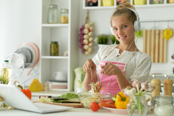 Obraz na płótnie Canvas Beautiful girl preparing a salad in the kitchen