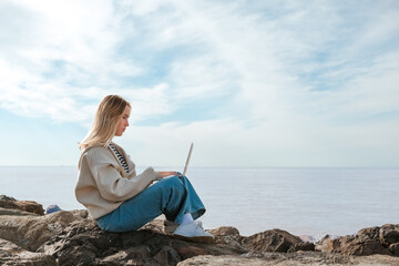 Remote work.Girl freelancer works remotely on the sea shore. workation, remote work,WFVH,Van Life...