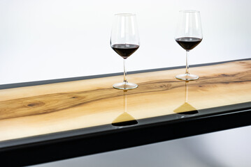 Coffee table, living room table. Resin handmade wood table. On a white background. Glass of whisky and glass of wine on the table.