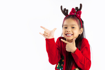 Cute asian kid girl in red sweater wearing reindeer horns headband smiling face posing fingers pointing