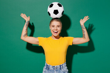 Young smiling woman fan wear basic yellow t-shirt cheer up support football sport team hold soccer...