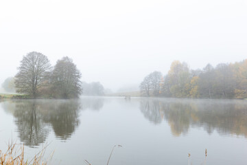 Foggy morning on the lake. Autumn landscape.