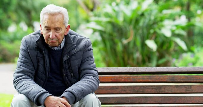 Relax, thinking and sad with old man on park bench with depression, tired and lonely in nature. Retirement, lost and mental health with senior citizen in outdoor relax in garden with anxiety problem