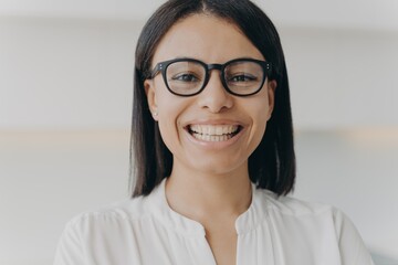 Smiling businesswoman wearing glasses looking at camera advertising eyeglass store. Sight correction